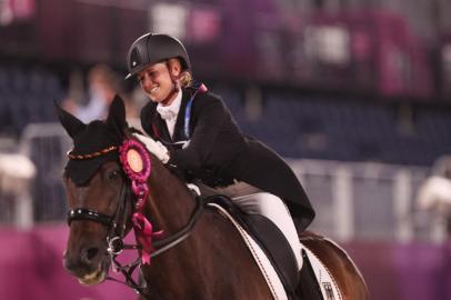 Gold medallist Germanys Jessica von Bredow-Werndl riding TSF Dalera poses after the medal ceremony for the dressage grand prix freestyle individual finals during the Tokyo 2020 Olympic Games at the Equestrian Park in Tokyo on July 28, 2021. (Photo by Julian Finney / POOL / AFP)<!-- NICAID(14846721) -->