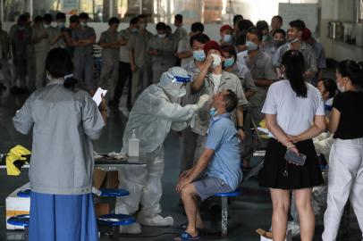 A worker receives a nucleic acid test for the Covid-19 coronavirus at the dining hall of a car parts factory in Wuhan, in Chinas central Hubei province on August 4, 2021. (Photo by STR / AFP) / China OUT<!-- NICAID(14853423) -->