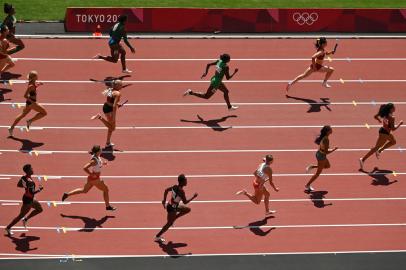 Athletes compete in the womens 4x100m relay heats during the Tokyo 2020 Olympic Games at the Olympic Stadium in Tokyo on August 5, 2021. (Photo by Ina FASSBENDER / AFP)<!-- NICAID(14854423) -->