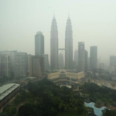 TOPSHOTSMalaysias iconic Petronas twin towers and Kuala Lumpurs skyline are shrouded in thick haze on October 21, 2015. Fires raging across huge areas of Indonesia are spewing more greenhouse gases into the atmosphere every day than the US economy, according to estimates from global environment watchdogs.   AFP PHOTO / MANAN VATSYAYANAEditoria: ENVLocal: Kuala LumpurIndexador: MANAN VATSYAYANASecao: Environmental pollutionFonte: AFPFotógrafo: STF