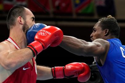 Russias Muslim Gadzhimagomedov (red) and Cubas Julio La Cruz fight during their mens heavy (81-91kg) boxing final bout during the Tokyo 2020 Olympic Games at the Kokugikan Arena in Tokyo on August 6, 2021. (Photo by THEMBA HADEBE / POOL / AFP)<!-- NICAID(14855786) -->