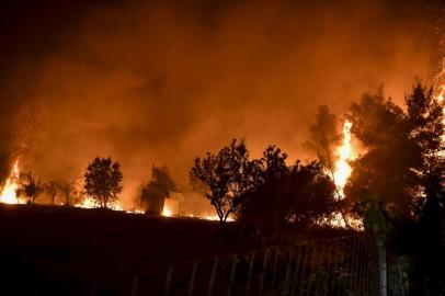 This photograph taken on August 5, 2021 shows trees burning as a fire spreads around the village of Afidnes, some 30 kilometres north of Athens. - Firefighters were battling a series of raging blazes in sweltering heat on August 5, 2021, in western and eastern Greece, and near Athens where a fire that had been coming under control regained strength. (Photo by LOUISA GOULIAMAKI / AFP)<!-- NICAID(14855787) -->