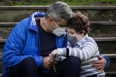 PORTO ALEGRE, RS, BRASIL, 05-08-2021: Davi de Lima Dresch, 6 anos, com o pai dele, Diego de Freitas Dresch, 40, numa praca na zona norte. O Diego e tecnico em enfermagem e fisioterapeuta no HPS. O filho e muito orgulhoso do pai porque ele salva muitas vidas. Durante a pandemia, Diego e a familia se afastaram dos demais parentes para evitar possivel contaminacao. Em marco deste ano, Diego perdeu o avo, referencia paterna, para a covid-19. Apesar de tudo, ele acredita que esse dia dos pais e de esperança, especialmente pelo nascimento do Gabriel, de dois meses, seu filho mais novo. (Foto: Mateus Bruxel / Agencia RBS)Indexador: Mateus Bruxel<!-- NICAID(14854983) -->