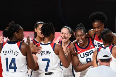 USAs players celebrate their victory at the end of the womens final basketball match between USA and Japan during the Tokyo 2020 Olympic Games at the Saitama Super Arena in Saitama on August 8, 2021. (Photo by Mohd RASFAN / AFP)<!-- NICAID(14857159) -->