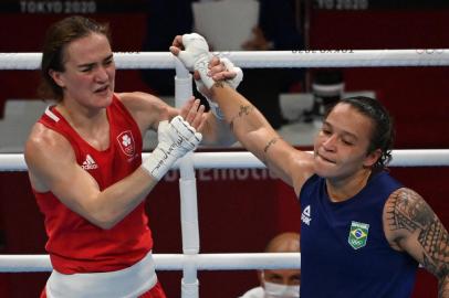 Irelands Kellie Anne Harrington (red) and Brazils Beatriz Ferreira celebrate after their womens light (57-60kg) boxing final bout during the Tokyo 2020 Olympic Games at the Kokugikan Arena in Tokyo on August 8, 2021. (Photo by Luis ROBAYO / AFP)<!-- NICAID(14857163) -->