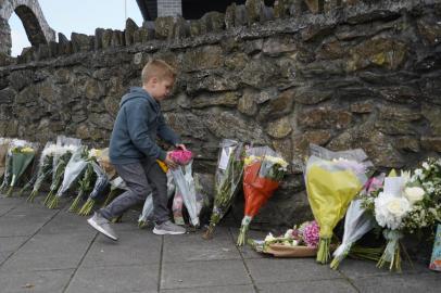 Tributos florais são colocados em uma calçada perto da cena de um tiroteio em Plymouth, sudoeste da Inglaterra, em 13 de agosto de 2021. - A polícia britânica disse em 13 de agosto que estava investigando o passado de um solitário problemático que obteve uma licença de arma de fogo e matou cinco pessoas, incluindo uma menina de três anos no primeiro tiroteio em massa no país em 11 anos. (Foto de Niklas HALLEN / AFP)<!-- NICAID(14862163) -->