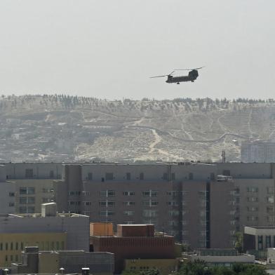 A US military helicopter is pictured flying above the US embassy in Kabul on August 15, 2021. (Photo by Wakil KOHSAR / AFP)<!-- NICAID(14862859) -->