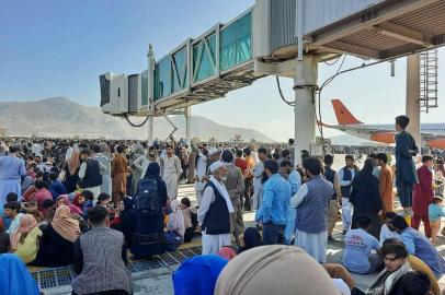 Afghans crowd at the tarmac of the Kabul airport on August 16, 2021, to flee the country as the Taliban were in control of Afghanistan after President Ashraf Ghani fled the country and conceded the insurgents had won the 20-year war. (Photo by - / AFP)<!-- NICAID(14863185) -->