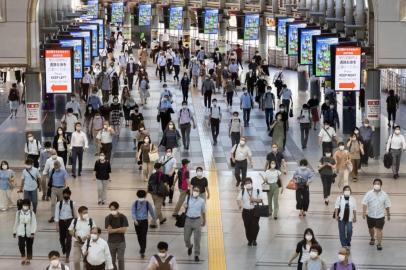 Commuters wear masks at a train station in Tokyo on August 10, 2021, as a coronavirus state of emergency remains in place in the city. (Photo by Yuki IWAMURA / AFP)<!-- NICAID(14864197) -->