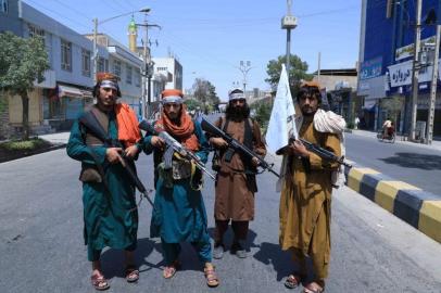 Taliban fighters stand guard along a road near the site of an Ashura procession which is held to mark the death of Imam Hussein, the grandson of Prophet Mohammad, along a road in Herat on August 19, 2021, amid the Talibans military takeover of Afghanistan. (Photo by AREF KARIMI / AFP)<!-- NICAID(14867335) -->