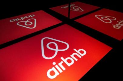 (FILES) This file photo taken on November 22, 2019 shows an illustration of the logo of the online accommodation platform Airbnb displayed on a tablet in Paris. - Online accommodation platform Airbnb offered on August 24, 2021, to house 20,000 Afghan refugees for free around the world, as people flee Kabul following the Taliban takeover. Airbnb has made it possible for hosts to offer temporary housing to people fleeing conflict and natural disasters through its Open Homes platform since 2012. (Photo by Lionel BONAVENTURE / AFP)<!-- NICAID(14870762) -->