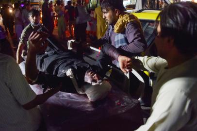 Medical and hospital staff bring an injured man on a stretcher for treatment after two blasts, which killed at least five and wounded a dozen, outside the airport in Kabul on August 26, 2021. (Photo by Wakil KOHSAR / AFP)Editoria: WARLocal: KabulIndexador: WAKIL KOHSARSecao: conflict (general)Fonte: AFPFotógrafo: STF<!-- NICAID(14872891) -->