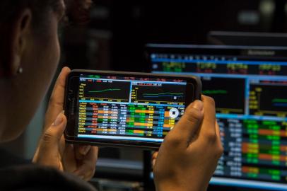 A visitor take pictures of a screen at the Sao Paulo Stock Exchange (B3), in Sao Paulo, Brazil, on May 18, 2017.Brazilian financial markets plummeted on opening Thursday in the wake of a bombshell report that President Michel Temer approved paying hush money to a corrupt politician. The real fell 5.46 percent against the dollar to 3.315, down from 3.134 at closing Wednesday, CMA consultants said. / AFP PHOTO / Nelson ALMEIDAEditoria: FINLocal: Sao PauloIndexador: NELSON ALMEIDASecao: foreign exchange marketFonte: AFPFotógrafo: STF<!-- NICAID(12920151) -->