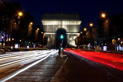 A photograph taken at night on September 16, 2021 shows the Arc de Triomphe in Paris, wrapped in silver-blue fabric, as it was designed by late artist Christo. - The 50-metre-high Arc de Triomphe in Paris has been wrapped in silvery-blue fabric as a posthumous tribute to Christo, who had dreamt of the project for decades. Bulgarian-born Christo, a longtime Paris resident, had plans for sheathing the imposing war memorial at the top of the Champs-Elysees while renting an apartment near it in the 1960s. (Photo by THOMAS COEX / AFP) / RESTRICTED TO EDITORIAL USE - MANDATORY MENTION OF THE ARTIST UPON PUBLICATION - TO ILLUSTRATE THE EVENT AS SPECIFIED IN THE CAPTION<!-- NICAID(14891632) -->