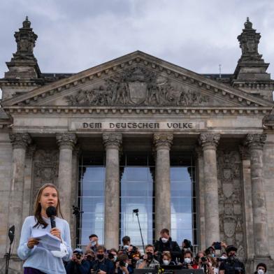 A ativista climática sueca Greta Thunberg está em frente ao prédio do Reichstag que abriga o Bundestag alemão (câmara baixa do parlamento) enquanto fala aos manifestantes que participam de uma greve climática global de Fridays for Future em Berlim em 24 de setembro de 2021, dois dias antes do Eleições federais alemãs. - Ativistas do movimento se manifestam em todo o mundo e em mais de 350 cidades alemãs para pedir mudanças estruturais por meio de medidas socialmente justas e consistentes para limitar o aquecimento global a 1,5 graus Celsius. Mais de 1160 campanhas foram planejadas em todos os continentes, anunciou o movimento. (Foto de John MACDOUGALL / AFP)<!-- NICAID(14898383) -->