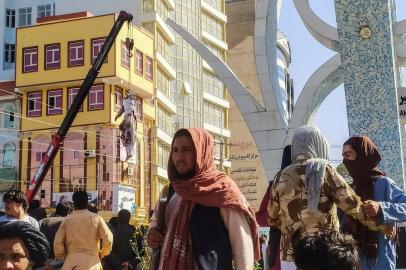 EDITORS NOTE: Graphic content / A dead body (top L) displayed in a public area is hanging on a crane in Herat on September 25, 2021, after Taliban killed four kidnappers during a shootout and hanged them, a senior official said. (Photo by - / AFP)<!-- NICAID(14899235) -->