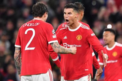 Manchester Uniteds Portuguese striker Cristiano Ronaldo (C) celebrates with Manchester Uniteds Swedish defender Victor Lindelof at the final whistle in the UEFA Champions league group F football match between Manchester United and Villarreal at Old Trafford stadium in Manchester, north west England, on September 29, 2021. - Manchester United won the match 2-1. (Photo by Anthony Devlin / AFP)<!-- NICAID(14902403) -->