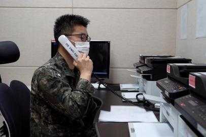 This handout photo taken and provided on October 4, 2021 by South Koreas Defence Ministry in Seoul shows a South Korean military officer speaking over a phone call with a North Korean official at an undisclosed location near the Demilitarized Zone (DMZ) dividing the two Koreas after North and South Korea restored their cross-border communications. (Photo by Handout / South Korean Defence Ministry / AFP) / RESTRICTED TO EDITORIAL USE - MANDATORY CREDIT AFP PHOTO / South Korean Defence Ministry - NO MARKETING NO ADVERTISING CAMPAIGNS - DISTRIBUTED AS A SERVICE TO CLIENTS<!-- NICAID(14905780) -->