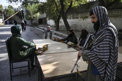 Taliban fighters sit outside the passport office after Taliban announced the reopening for passport applications, in Kabul on October 6, 2021. (Photo by WAKIL KOHSAR / AFP)<!-- NICAID(14908662) -->