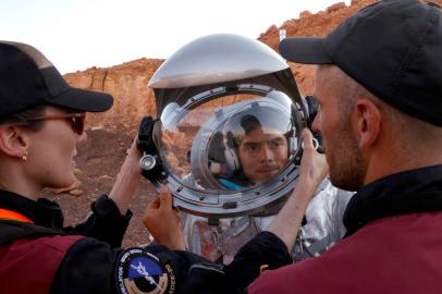 Technicians assist an astronaut from a team from Europe and Israel to suit up in a spacesuit before starting a training mission for planet Mars at a site that simulates an off-site station at the Ramon Crater in Mitzpe Ramon in Israels southern Negev desert on October 10, 2021. - Six astronauts from Portugal, Spain, Germany, the Netherlands, Austria, and Israel will be cut off from the world for a month, from October 4-31, only able leave their habitat in spacesuits as if they were on Mars. Their mission, the AMADEE-20 Mars simulation, will be carried out in a Martian terrestrial analog and directed by a dedicated Mission Support Center in Austria, to conduct experiments ahead of future human and robotic Mars exploration missions. (Photo by JACK GUEZ / AFP)<!-- NICAID(14912392) -->