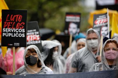 Porto Alegre, RS, Brasil, 15-10-2021: No Dia do Professor, professores(as) e funcionários(as) de escolas de todo o RS realizam ato para exigir 47,82% de reposição salarial e denunciar os incessantes ataques do governo Leite aos trabalhadores(as) da educação da ativa e aposentados(as). Os educadores amargam sete anos de salários congelados, sem um centavo de reajuste, desde novembro de 2014. Sob chuva, eles carregaram um caixão em marcha fúnebre pela educação. Em frente ao Palácio Piratini, uma performance encerra o ato. (Foto Mateus Bruxel / Agencia RBS)Indexador: Mateus Bruxel<!-- NICAID(14916241) -->