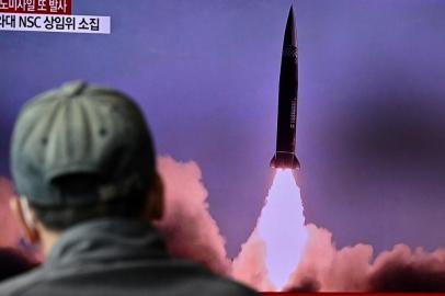 A man watches a television report showing a news broadcast with file footage of a North Korean missile test, at a railway station in Seoul on October 19, 2021, after the Souths military said a North Korean weapons test was believed to be a submarine-launched ballistic missile. (Photo by Anthony WALLACE / AFP)<!-- NICAID(14918696) -->