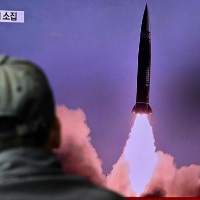 A man watches a television report showing a news broadcast with file footage of a North Korean missile test, at a railway station in Seoul on October 19, 2021, after the Souths military said a North Korean weapons test was believed to be a submarine-launched ballistic missile. (Photo by Anthony WALLACE / AFP)<!-- NICAID(14918696) -->