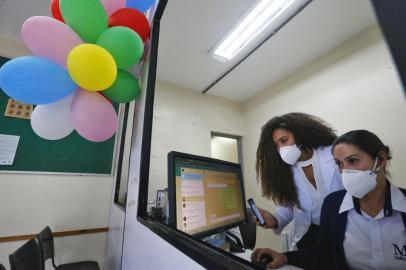 PORTO ALEGRE, RS, BRASIL - 18.10.2021 - como funciona o atendimento da unidade de saúde Osmar Freitas pelo WhatsApp. Os 132 serviços receberam aparelhos celulares com o aplicativo e farão listas de transmissão com o contato dos pacientes, além de prestar informações. Na foto, em pé, Jéssica Hilário de Lima, enfermeira gerente da unidade e Taína Paola Araújo da Silva, recepcionista. (Foto: Lauro Alves/Agencia RBS)<!-- NICAID(14918348) -->