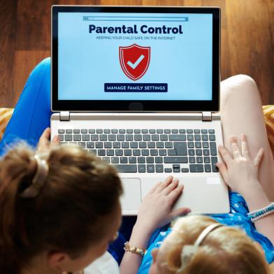 mother and daughter setting up parental control on laptopmodern mother and daughter sitting on sofa in the modern living room setting up parental control on a laptop.Fonte: 277584916<!-- NICAID(14921368) -->