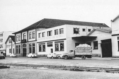 A fachada da Cooperativa Vinícola São Victor, na Rua Augusto Pestana, em frente à Estação Férrea, em meados dos anos 1970, com o vaivém de caminhões tomados de garrafões.<!-- NICAID(14922053) -->