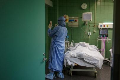 This file picture taken on October 20, 2021, shows a medic wearing a personal protective equipment (PPE) working in the intensive care unit for Covid-19 coronavirus patients in the Moscow Sklifosovsky emergency hospital in Moscow. - Russian authorities said on November 1, 2021, that doctors were under extraordinary strain due to surging coronavirus cases in Europes worst-hit country, with Moscow shuttered during a nationwide holiday to curb infections. Russia is one of the worst-hit countries in the world and a devastating wave this autumn has seen infections and deaths reach new records, with more than 1,000 fatalities per day. (Photo by Dimitar DILKOFF / AFP)<!-- NICAID(14937176) -->