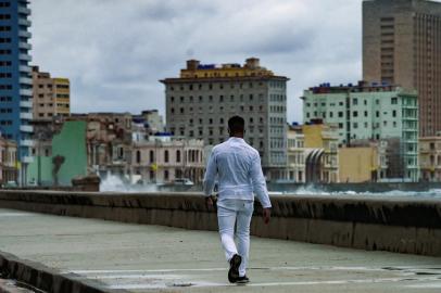 A man walks along Havanas malecon, on November 15, 2021. - The Cuban opposition has said it will take to the streets as planned on Monday to demand the release of political prisoners, despite authorities banning the demonstration and preventing its organizers leaving their homes the day before. News of the 15N (November 15) gathering in Havana and six provinces has spread rapidly on Cuban social media platforms in past weeks, with opposition supporters planning to highlight the continued detention of hundreds of prisoners jailed since history-making protests in July. (Photo by Yamil LAGE / AFP)<!-- NICAID(14941467) -->