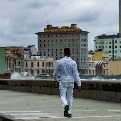 A man walks along Havanas malecon, on November 15, 2021. - The Cuban opposition has said it will take to the streets as planned on Monday to demand the release of political prisoners, despite authorities banning the demonstration and preventing its organizers leaving their homes the day before. News of the 15N (November 15) gathering in Havana and six provinces has spread rapidly on Cuban social media platforms in past weeks, with opposition supporters planning to highlight the continued detention of hundreds of prisoners jailed since history-making protests in July. (Photo by Yamil LAGE / AFP)<!-- NICAID(14941467) -->