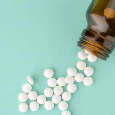 White round tablets scattered near glass bottle of pillsPORTO ALEGRE, RS, BRASIL,24/10/2019- Comprimidos redondos brancos espalhados. (Foto: ironstealth / stock.adobe.com)Indexador: A.KhoruzhenkoFonte: 290067398<!-- NICAID(14302401) -->