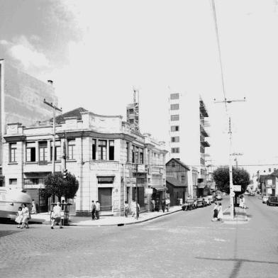 Esquina da Av. Júlio de Castilhos com a Rua Visconde de Pelotas por volta de 1957. Foi nesse cruzamento que foi instalada a primeira sinaleira automática de Caxias do Sul, em 1 de setembro de 1951. Vê-se na foto o recém-construído Edifício Prataviera (atual Prataviera Shopping) e o casarão da esquina que abrigou a primeira sede da loja (atual Farmácia Panvel). Ali também funcionou o Consultório do Dr. Virvi Ramos.<!-- NICAID(14937320) -->