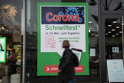 A passer-by walks in front of a Covid-19 test station, on November 17, 2021 in Berlin, amid the novel coronavirus / COVID-19 pandemic. (Photo by STEFANIE LOOS / AFP)<!-- NICAID(14943300) -->