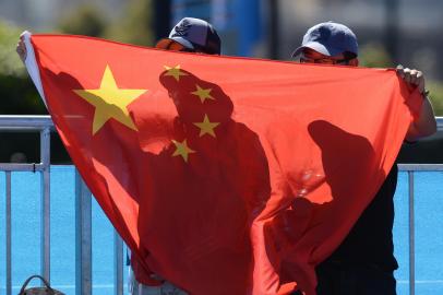 Supporters wave a flag as they cheer for Zhang Yuxuan of China and compatriot Zheng Zie during their womens singles match on the first day of the Australian Open tennis tournament in Melbourne on January 14, 2013.   AFP PHOTO/MANAN VATSYAYANA IMAGE STRICTLY RESTRICTED TO EDITORIAL USE - STRICTLY NO COMMERCIAL USE<!-- NICAID(9010182) -->