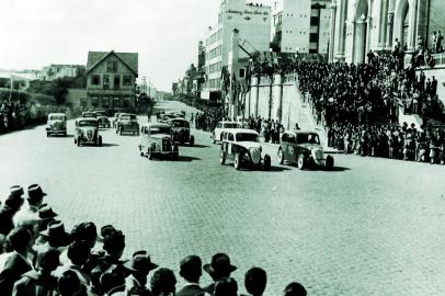 Largada da primeira prova automobilística realizada dentro da cidade de Caxias do Sul, 1952, aparecendo, na direita, a Catedral e Eberle.<!-- NICAID(14949695) -->