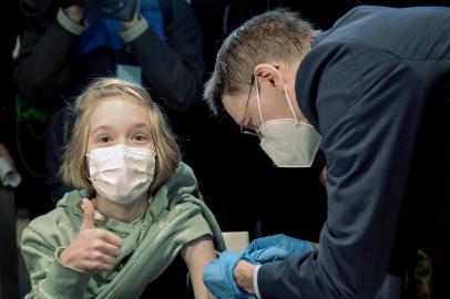 German Health Minister Karl Lauterbach vaccinates ten-year-old Frida at the vaccination centre at the Zoo in Hanover on December 17, 2021 as the vaccination of children aged 5 to 11 against the Covid-19 virus started this week in Germany. (Photo by Ronny HARTMANN / AFP)Editoria: HTHLocal: HanoverIndexador: RONNY HARTMANNSecao: governmentFonte: AFPFotógrafo: STR<!-- NICAID(14973572) -->