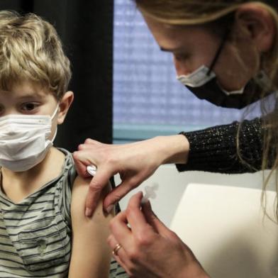 A child receives a dose of the Pfizer/BioNTech vaccine against Covid-19, in Paris, on December 17, 2021. - Frances President said on December 15, 2021 that the vaccination of children against Covid-19 was desirable but ruled out an obligation, believing that it was the choice of parents adding that Between 5 and 11 years, the health authorities have explained that it would protect, and therefore I think it is desirable. (Photo by GEOFFROY VAN DER HASSELT / AFP)<!-- NICAID(14974252) -->