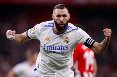 ESP - FUTEBOL/CAMPEONATO ESPANHOL/ATHLETIC BILBAO/REAL MADRID - ESPORTES - Karim Benzema, do Real Madrid, comemora depois de marcar seu gol durante a partida   de futebol contra o Athletic Bilbao, no estádio San Mames, em Bilbao, na Espanha,   nesta quarta-feira, 22 de dezembro de 2021. Com grande atuação de Éder Militão,   Toni Kross e Benzema, o Real Madrid superou a pressão do time do Athletic Bilbao e   de seus 42 mil torcedores para vencer, nesta quarta-feira, por 2 a 1, e aumentar a   vantagem na classificação do Campeonato Espanhol. Com a 14ª vitória em 19 partidas   disputadas, o Real alcança os 46 pontos, oito a mais que o vice-líder Sevilla, que   se apresentou apenas 18 vezes. O Athletic Bilbao, com 24 pontos, é o décimo   colocado.   22/12/2021 - Foto: RICARDO LARREINA/ASSOCIATED PRESS/ESTADÃO CONTEÚDO<!-- NICAID(14975554) -->