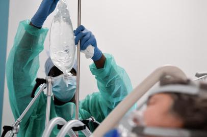 A nurse tends to a Covid-19 patient at the intensive care unit of the Delafontaine AP-HP hospital in Saint-Denis, outside Paris, on December 29, 2021. - A tidal wave with a record of more than 200,000 Covid-19 infections in 24 hours : Health Minister Olivier Veran brandished these dizzying figures on December 29, 2021 to defend the bill to transform the health pass into a vaccination pass. (Photo by ALAIN JOCARD / AFP)Editoria: HTHLocal: Saint-DenisIndexador: ALAIN JOCARDSecao: hospital and clinicFonte: AFPFotógrafo: STF<!-- NICAID(14979302) -->