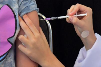 A girl receives the first dose of the Pfizer-BioNTech vaccine against COVID-19, at the Clinicas hospital in Sao Paulo, Brazil, on January 14, 2022. (Photo by NELSON ALMEIDA / AFP)Editoria: HTHLocal: Sao PauloIndexador: NELSON ALMEIDASecao: diseaseFonte: AFPFotógrafo: STF<!-- NICAID(14990110) -->