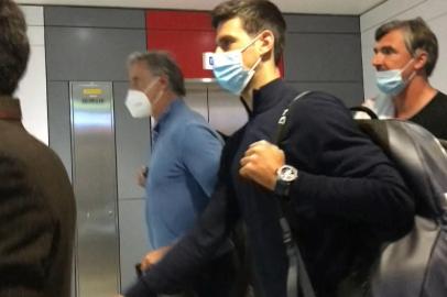 This screen grab from AFPTV shows Serbias Novak Djokovic (C) as he disembarks from his plane at the airport in Dubai on January 17, 2022, after losing a legal battle on January 16 in Australia to stay and play in the Australian Open tennis tournament over his coronavirus vaccination status. (Photo by AFPTV / AFP)<!-- NICAID(14991956) -->