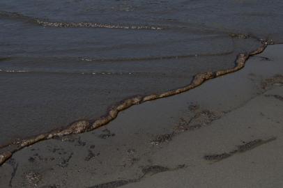 Oil wash ashore at a beach in the Peruvian province of Callao on January 17, 2022, after a spill which occurred during the unloading process of the Italian-flagged tanker Mare Doricum at La Pampilla refinery caused by the abnormal waves recorded after the volcanic eruption in Tonga. - A massive volcanic eruption in Tonga triggered tsunami waves around the Pacific, with waves strong enough to drown two women in Peru, more than 10,000 kilometres (6,000 miles) away. (Photo by Cris BOURONCLE / AFP)<!-- NICAID(14992216) -->