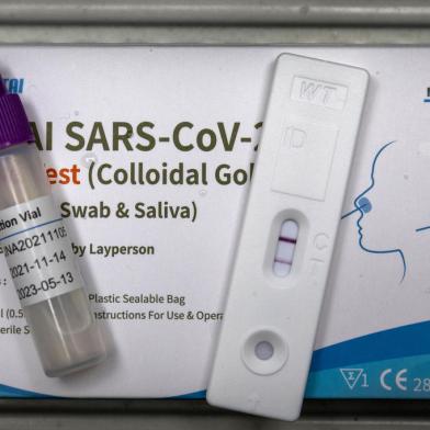 A used rapid antigen test, also known as a lateral flow test showing a positive test result for the Covid-19 coronavirus is photographed in Berlin on January 17, 2022. - Taking a test involves doing swab from inside your nostril or in your throat, depending on the test you are using, before mixing the swab with solution and dripping it onto a container with a test strip with antibodies specific to the Covid-19 virus painted on it in a thin line. If the testing strip detects the virus, it shows up as a red line next to the T on the container, the line next to the Cshould always be visible. (Photo by Odd ANDERSEN / AFP)Editoria: HTHLocal: BerlinIndexador: ODD ANDERSENSecao: diseaseFonte: AFPFotógrafo: STF<!-- NICAID(14993775) -->