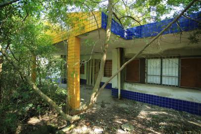 PORTO ALEGRE,RS,BRASIL.2022,01,22.Escola que foi construida no Bairro Rubem Berta, ha 14 anos, e que nunca teve um aluno, foi saqueada, roubaram portas,janelas, vidros e esquadrias, a escola esta encravada no meio do mato, e sendo habitada por três familas, e até mesmo com churrasqueira improvisada.(RONALDO BERNARDI/AGENCIA RBS).<!-- NICAID(14996531) -->