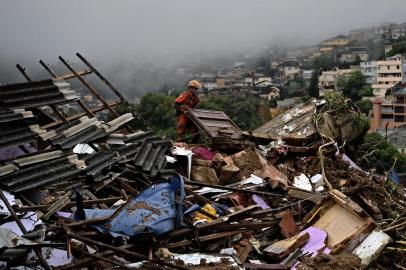 A member of the fire services rescue team lifts rubble to look for survivors in a mudslide in Petropolis, Brazil on February 16, 2022. Large scale flooding destroyed hundreds of properties and claimed at least 34 lives in the area. (Photo by CARL DE SOUZA / AFP)Editoria: DISLocal: PetrópolisIndexador: CARL DE SOUZASecao: disaster (general)Fonte: AFPFotógrafo: STF<!-- NICAID(15017870) -->