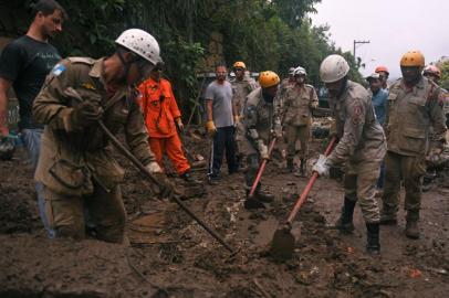 Firefighters and volunteers are seen during a rescue mission after a giant landslide at Caxambu neighborhood in Petropolis, Brazil, on February 19, 2022. - A total of 136 bodies have been retrieved to date, according to civil defense officials, in the normally scenic tourist town some 60 kilometers (37 miles) north of Rio de Janeiro. (Photo by MAURO PIMENTEL / AFP)<!-- NICAID(15021847) -->