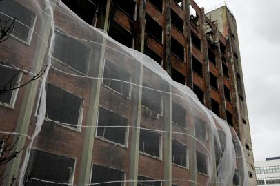 PORTO ALEGRE, RS, BRASIL, 01-03-2022: Protecao instalada ao redor da estrutura que abrigava a Secretaria de Seguranca Publica do RS. Processo de envelopamento do predio para a implosao, no proximo domingo. Edificio da SSP foi destruido por incendio. (Foto: Mateus Bruxel / Agencia RBS)Indexador: Mateus Bruxel<!-- NICAID(15029891) -->